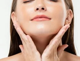 Woman with both hands on her face. Cropped image focused on her face