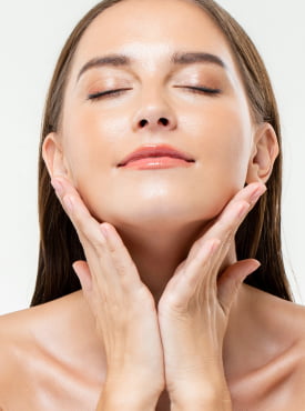 Woman with both hands on her face. Cropped image focused on her face