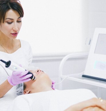 Doctor perfoming a cosmetic procedure in a woman patient