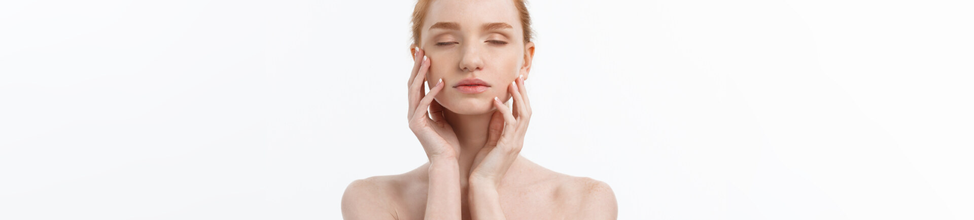 white woman touching her face in front of white background