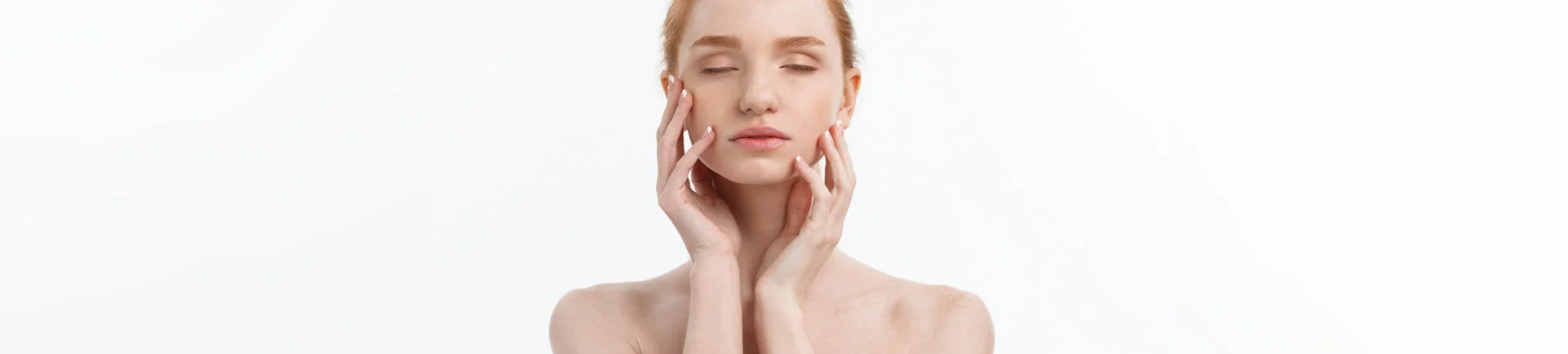 white woman touching her face in front of white background