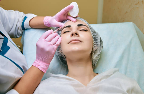 dermal fillers being injected into a women with a nurse and pink gloves